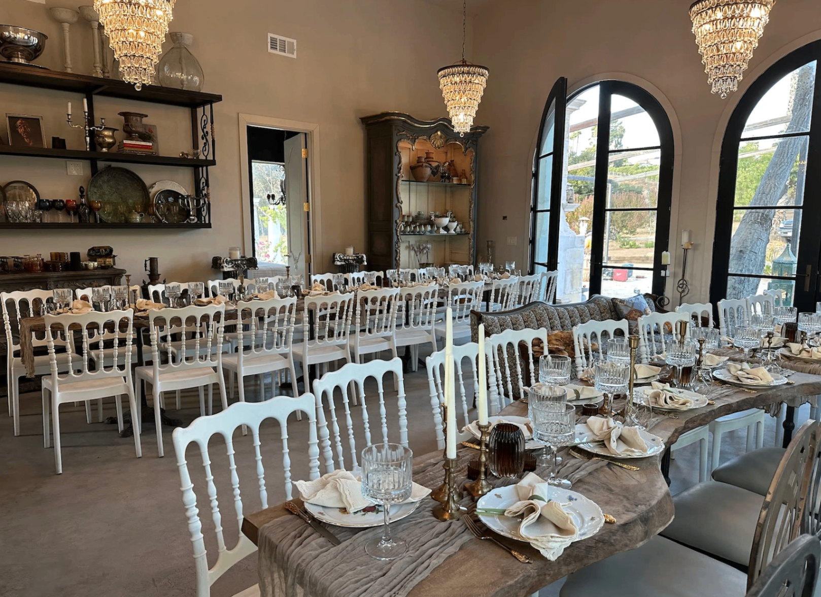 Wide interior dining room with chandeliers and long banquet tables